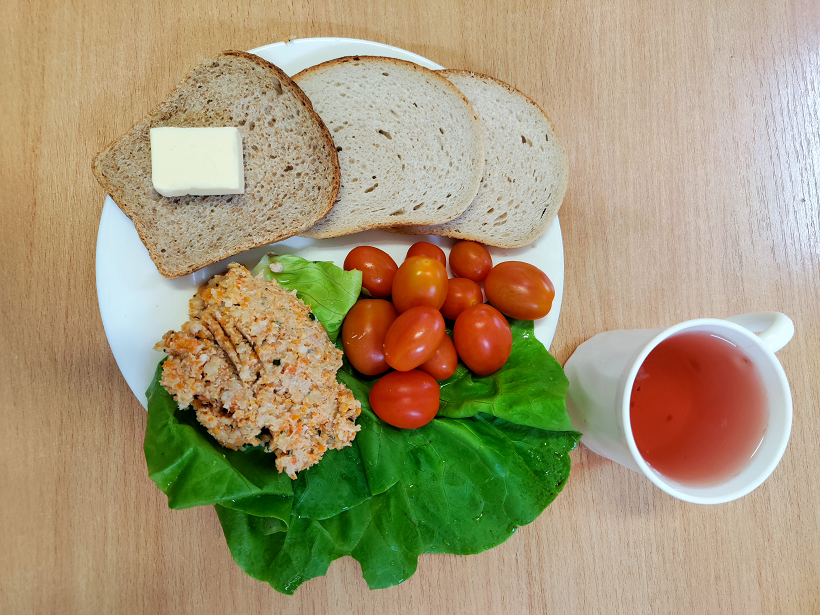 Na zdjęciu znajduje się: Pomidorki koktajlowe, Herbata owocowa, Chleb mieszany pszenno-żytni, Chleb Graham, Masło extra 82%, Pasta mięsno-warzywna, z mięsa drobiowego udziec, ​​​​​​​Sałata zielona